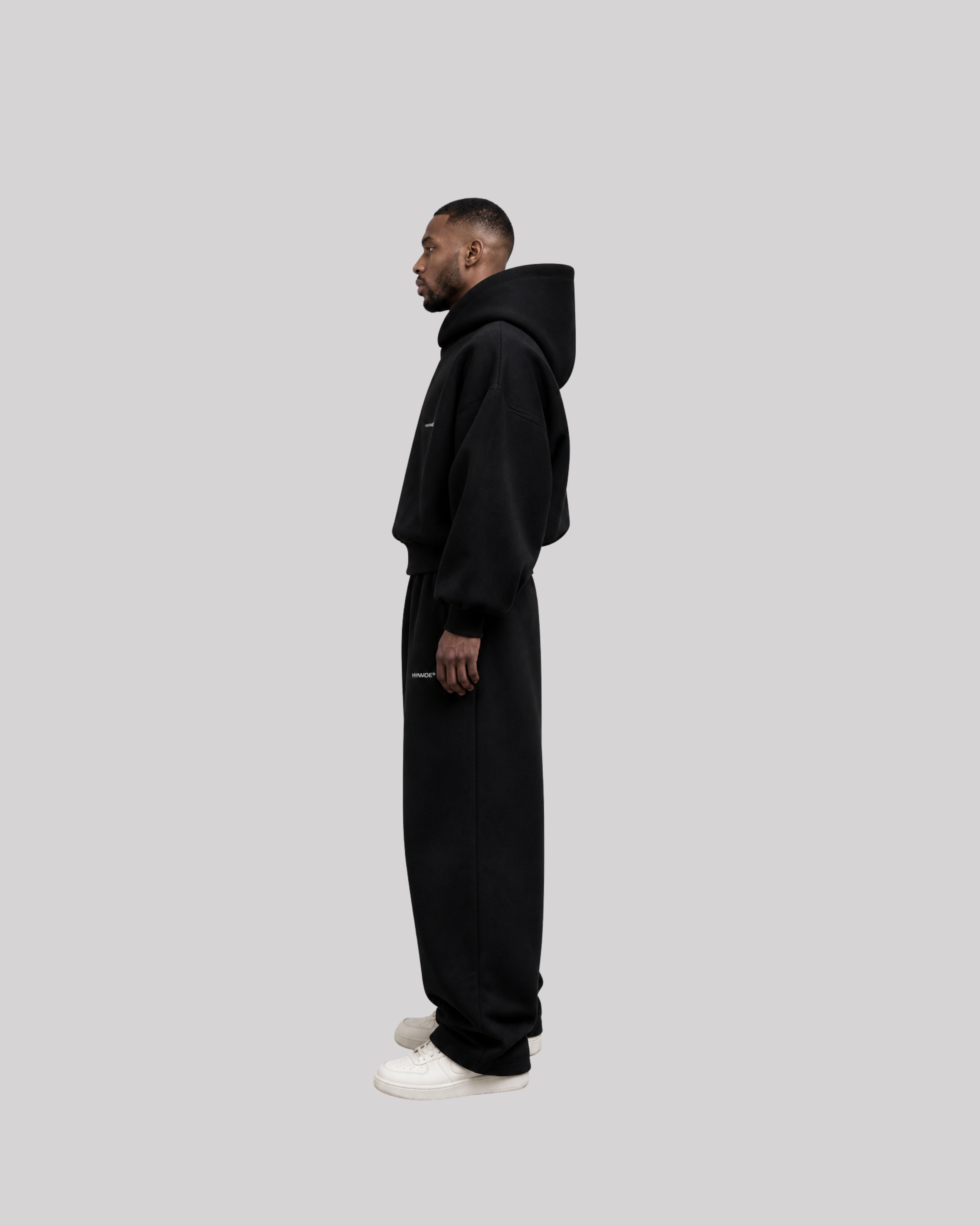 Person wearing a black top and blue jeans on a white background
